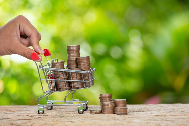 World Habitat Day,close up picture of  a hand pushing little cart which full of coins