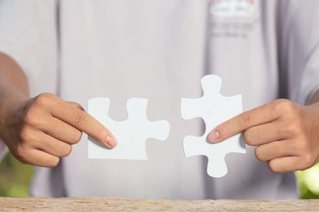 World Habitat Day,close up picture of  a piece of white jigsaw in each hand