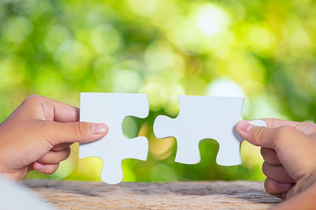 World Habitat Day,close up picture of  a piece of white jigsaw in each hand