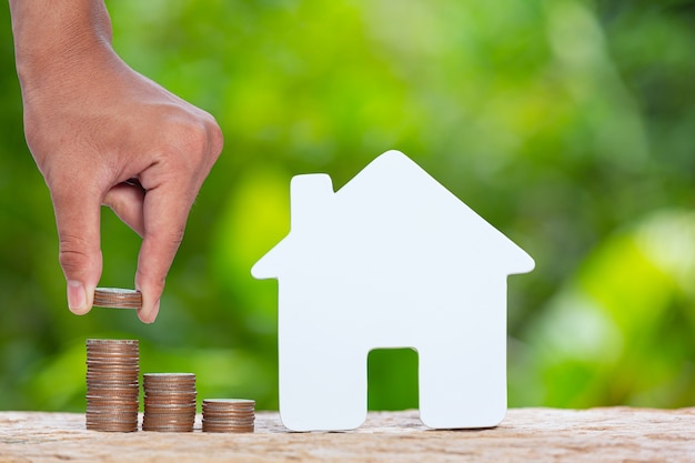 World Habitat Day,close up picture of a pile of coins and a model house