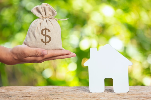 Free photo world habitat day,close up picture of a sack of coins and a model house