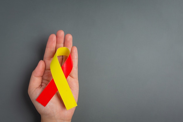 Free photo world hepatitis day awareness with red yellow ribbon