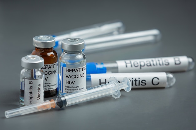 Концепция всемирного дня гепатита с медицинскими инструментами и таблетками, помещенными на серую поверхность
