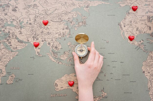 World map background with decorative hearts and compass in the middle