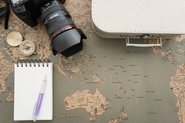 World map background with notebook and other travel objects