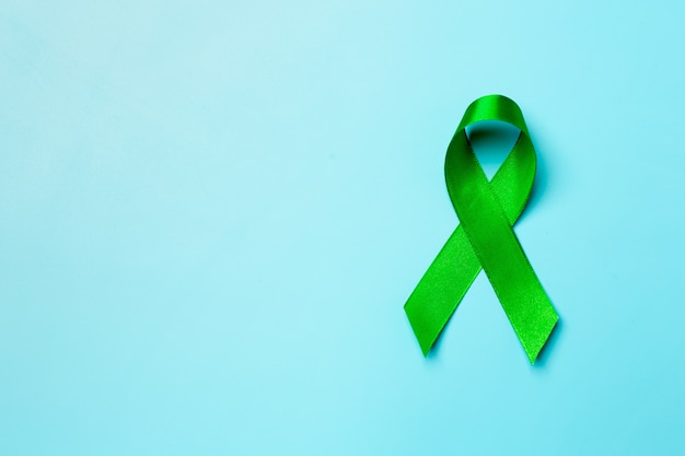World Mental Health Day. green ribbon on blue background