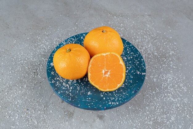 大理石の表面にオレンジが入ったココナッツパウダーで覆われた使い古した大皿