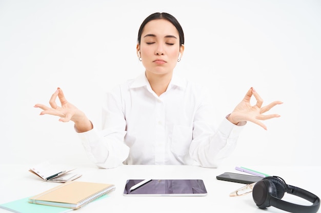 Free photo worplace and working environment young woman sits in office with tablet and documents keeps calm med