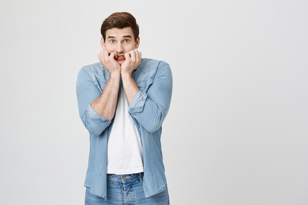 Worried brunette man looking scared, trembling fear