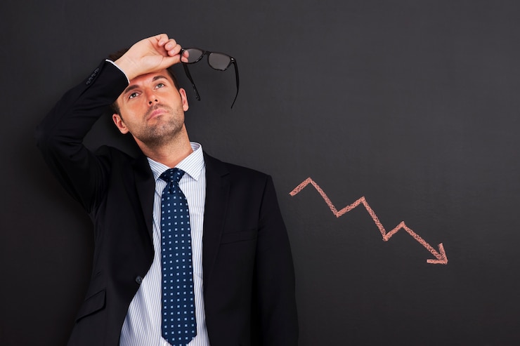 Free Photo worried businessman with sign of decreased profit