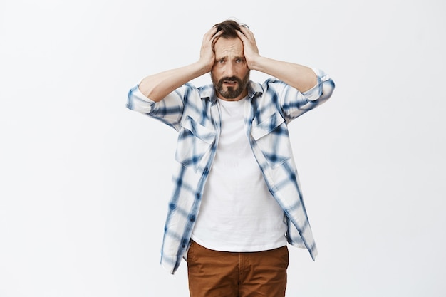 Free photo worried and distressed bearded mature man posing