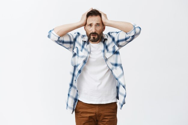 Worried and distressed bearded mature man posing