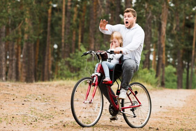 Взволнованный отец и дочь на велосипеде