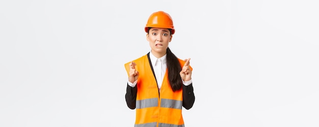 Worried hopeful asian female architect feeling nervous as waiting for inspection results at construc
