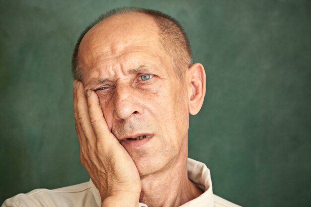 Worried mature man touching his head and thinking on.