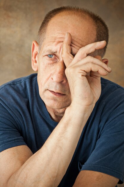 Worried mature man touching his head.