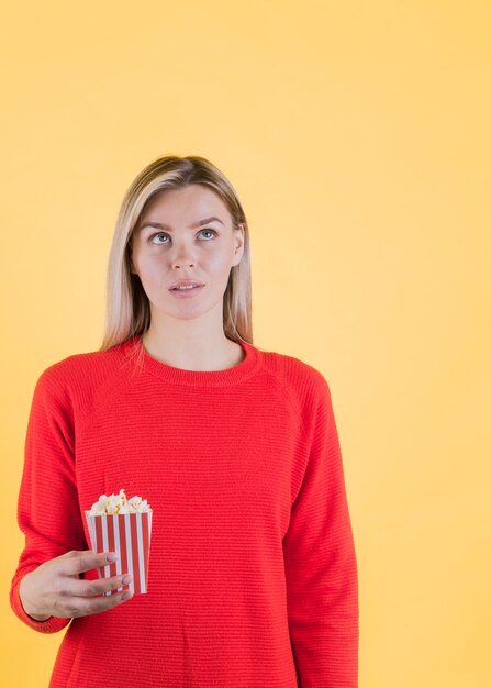 Worried model holding popcorn