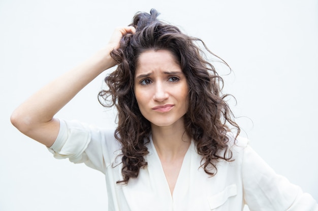 Free photo worried pensive woman scratching head