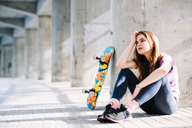 Worried sports girl sitting on the floor