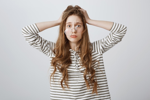 Free photo worried and stressed woman in crooked glasses panicking, got in trouble