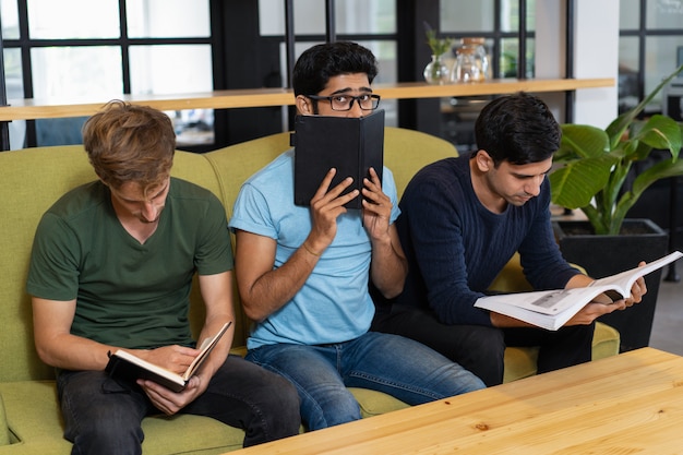 Worried student hiding behind notebook and sitting