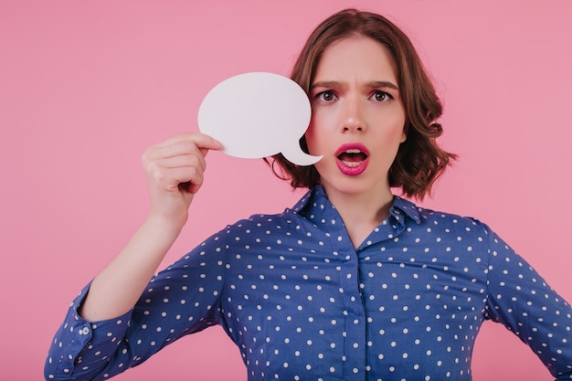 Foto gratuita giovane signora alla moda preoccupata in abbigliamento blu che pensa a qualcosa. magnifica ragazza nervosa isolata sul muro rosa.