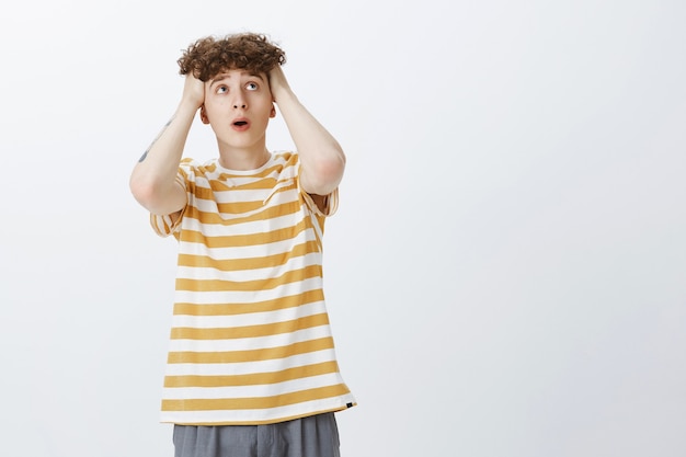 Free photo worried and troubled teenage guy posing against the white wall