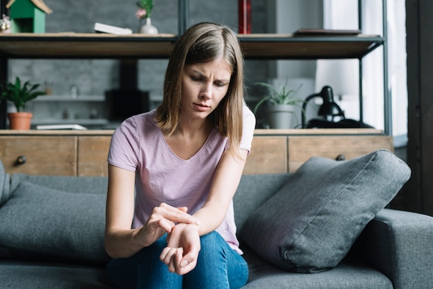 Worried woman checking her pulse at home