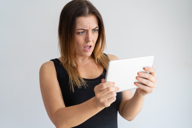 Worried woman looking at tablet screen