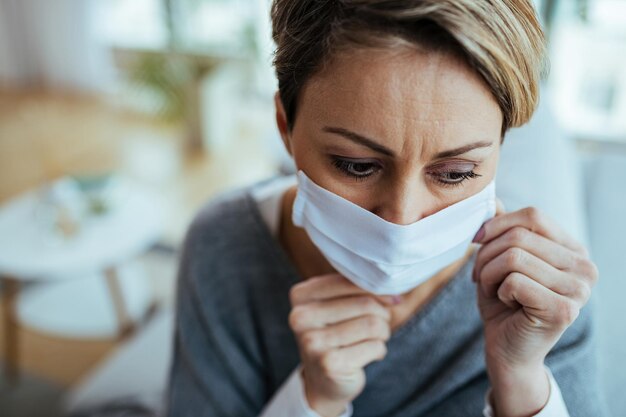 Worried woman putting on N95 face mask during virus pandemic