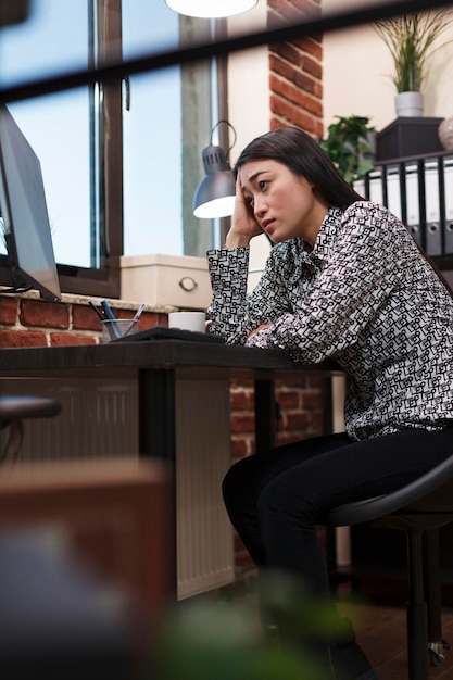 무료 사진 걱정된 젊은 여성 사업가가 사무실 컴퓨터 화면의 관리 차트를 무기력하게 보고 있습니다. 회계 번호를 잘못 입력한 이해하려고 피곤한 비즈니스 회계사.