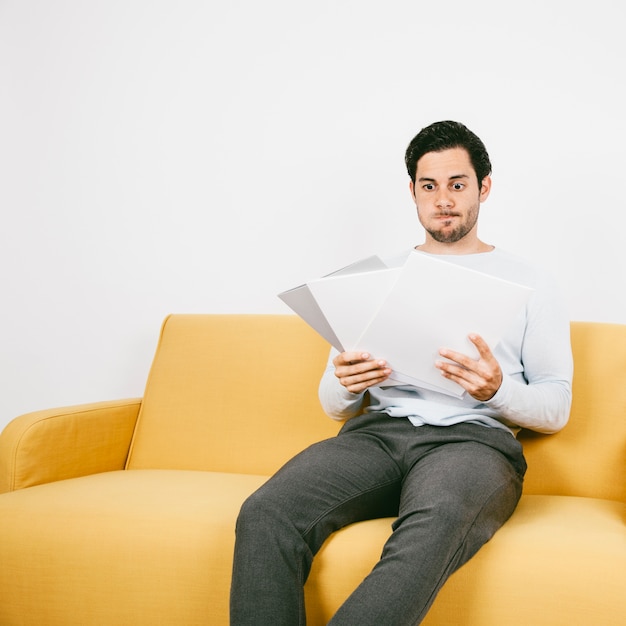 Worried young man looking at papers