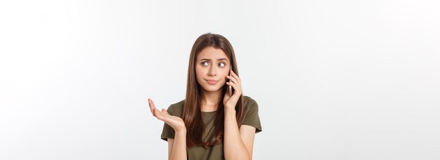 Worried young woman looks nervously female is nervous while talking on the phone feels frustrated an