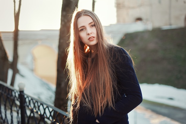 Worried young woman with long hair outdoors
