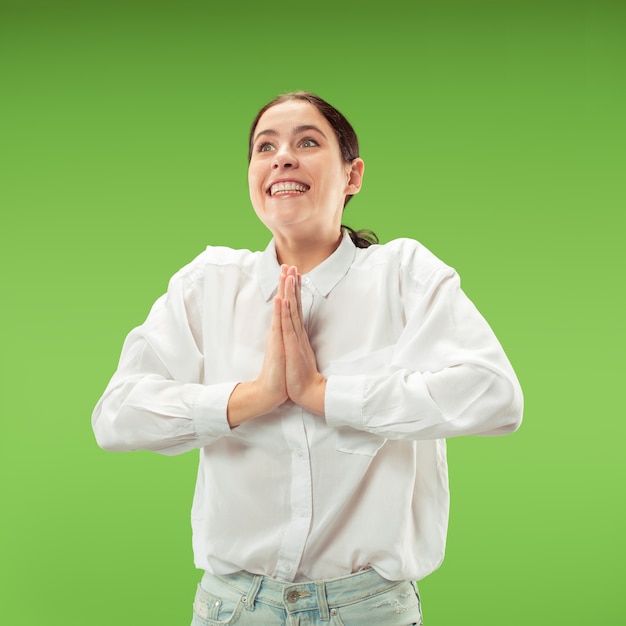 Бесплатное фото Вау. красивый женский поясной передний портрет изолированный на зеленом backgroud. молодая эмоциональная удивленная женщина, стоящая с открытым ртом