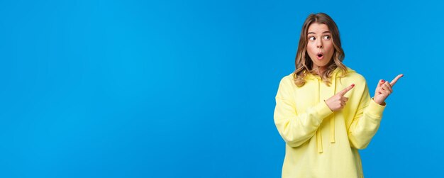 Wow something interesting intrigued and surprised alluring blond woman in yellow hoodie talking abou