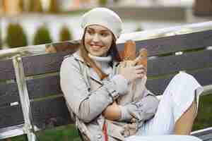 Free photo wowan in a white beret  in a city with a baguette