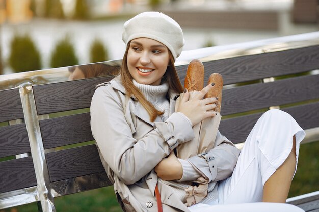 Wowan in a white beret  in a city with a baguette