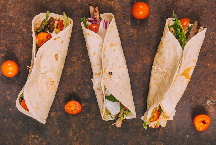 Free Photo wrap mexican beef tacos with tomatoes on rusty background