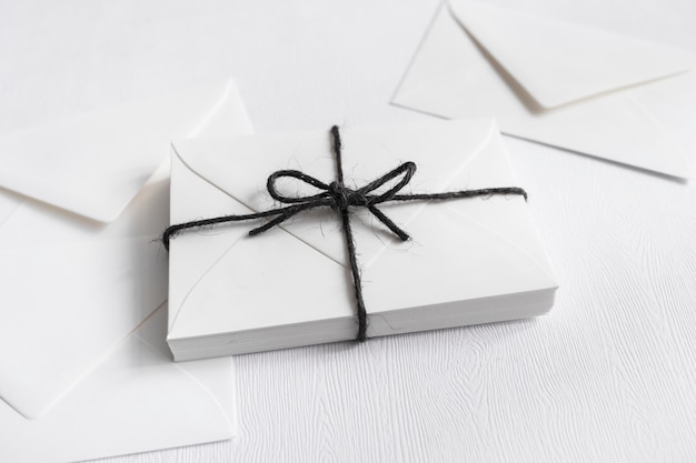 흰색 배경에 검은 끈과 봉투로 묶인 포장 된 선물 상자
