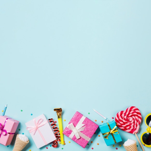 무료 사진 포장 된 선물 상자; 와플 하나; 사광; 선글라스와 파란색 배경에 심장 모양 사탕