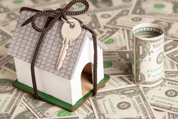 Wrapped house with keys on money background