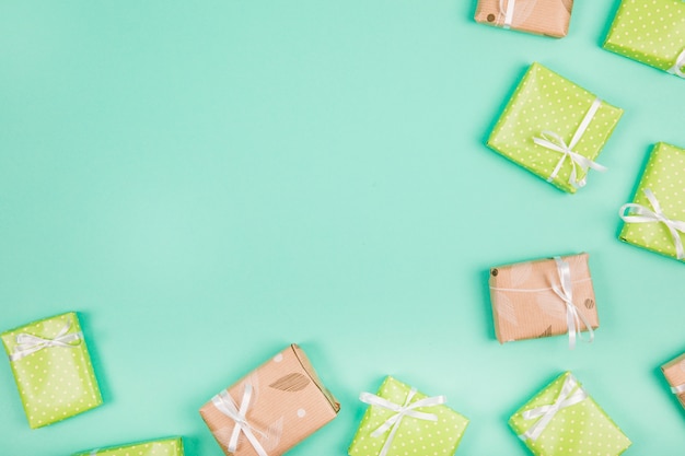 Wrapped presents tied with white ribbon bow on green backdrop