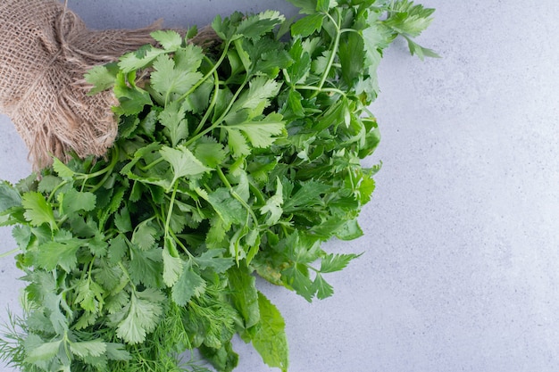 Wrapping of parsley bundle on marble background. High quality photo