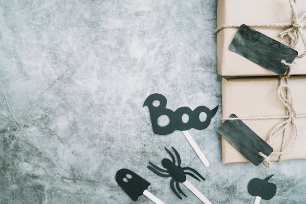 Free photo wrappings with handmade dark labels lying on side next to halloween attributes