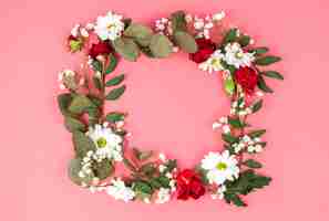 Free photo wreath made from red and white flowers in front of peach background