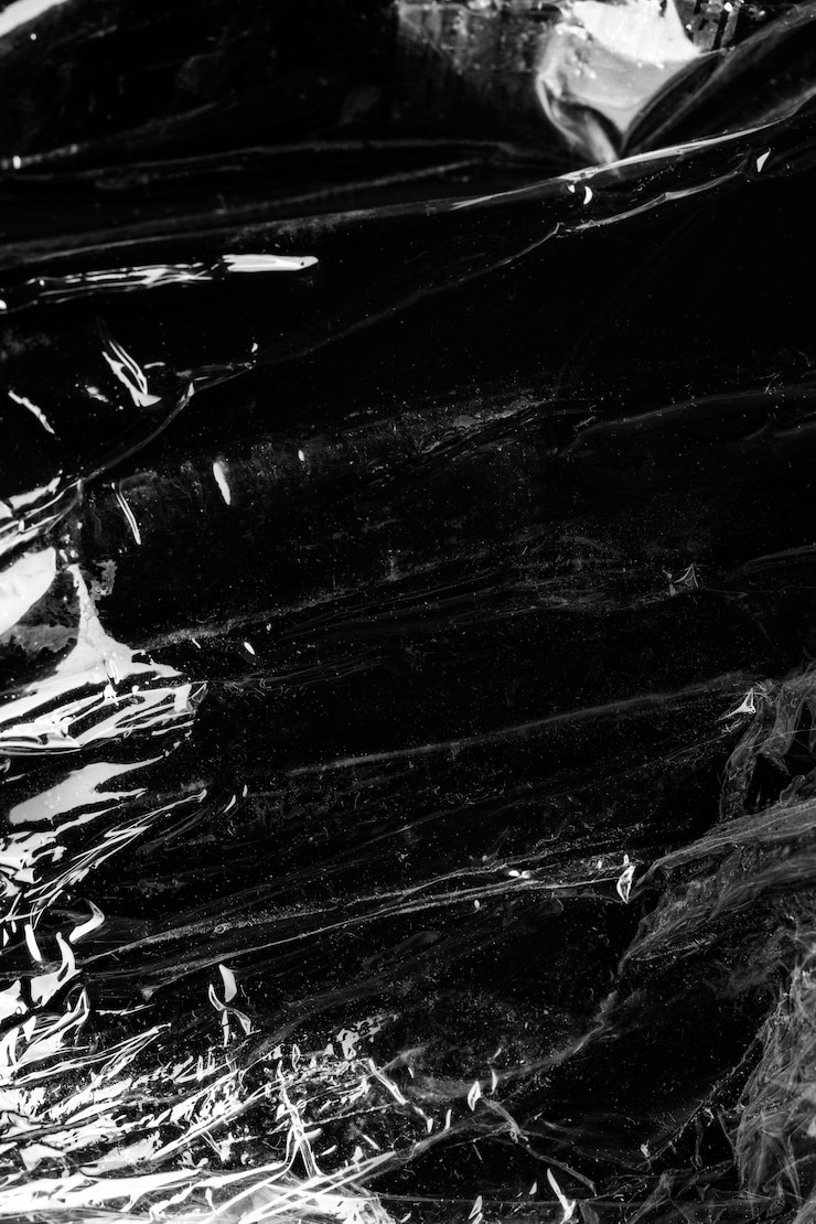 Free Photo wrinkled plastic wrap texture on a black background