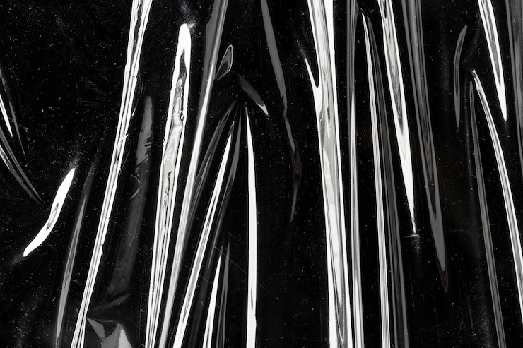 Free Photo wrinkled plastic wrap texture on a black background
