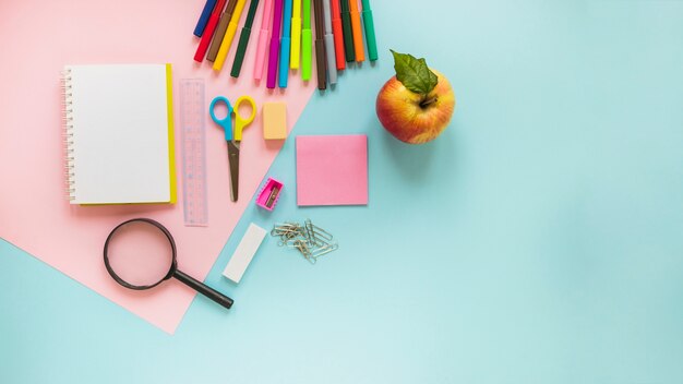 Writing implements and apple laid in order