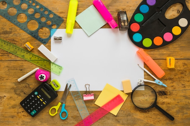 Writing implements laid around piece of paper